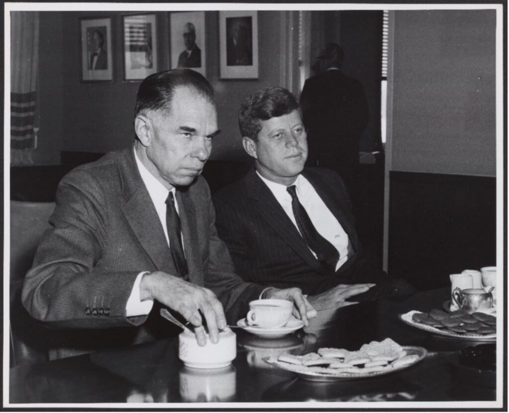 总统约翰F肯尼迪和Glenn Seaborg穿西装和深带他们坐在表加咖啡和曲奇