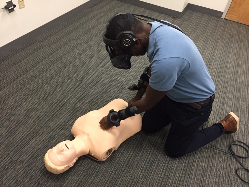 男子使用虚拟现实头盔对虚拟人进行心肺复苏