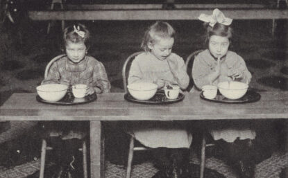三个孩子坐在表边吃